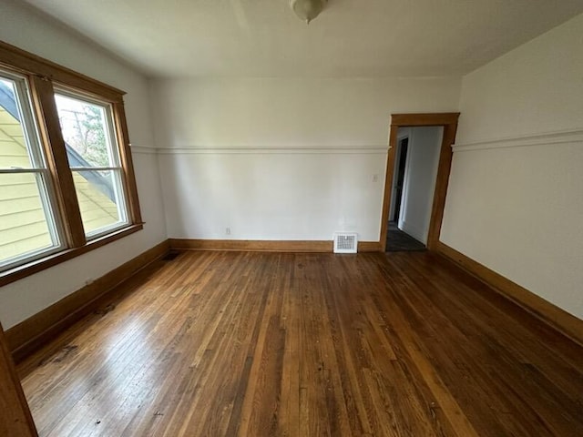 empty room with dark hardwood / wood-style flooring