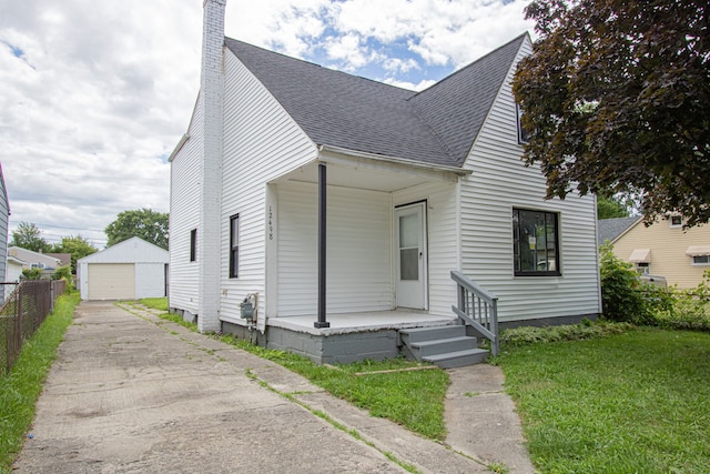 view of front of property featuring an outbuilding, a front lawn, a porch, and a garage