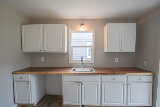 kitchen featuring white cabinets, dark hardwood / wood-style floors, and sink