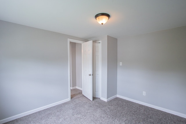 unfurnished bedroom featuring a closet and light colored carpet