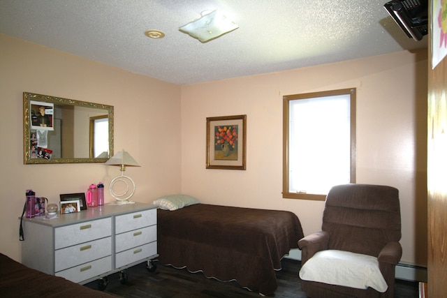 bedroom with a textured ceiling and dark hardwood / wood-style floors