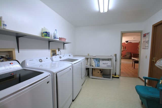 clothes washing area with washing machine and dryer and light wood-type flooring