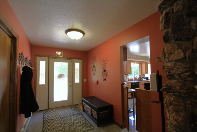 carpeted entrance foyer with a textured ceiling