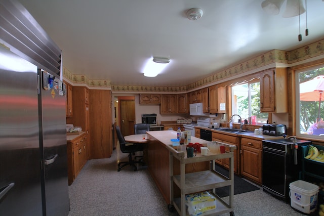 kitchen with light carpet, sink, a center island, and white appliances