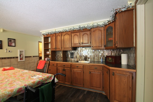 kitchen featuring kitchen peninsula, a textured ceiling, dark hardwood / wood-style floors, and sink