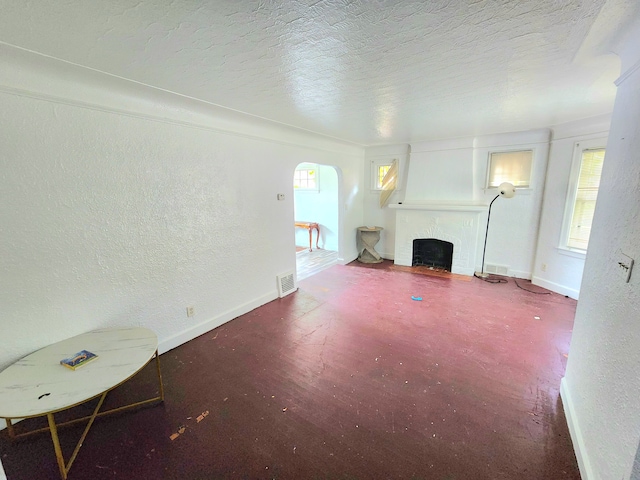 unfurnished living room featuring a textured ceiling and a large fireplace