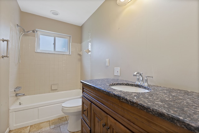 full bathroom with tiled shower / bath, vanity, and toilet