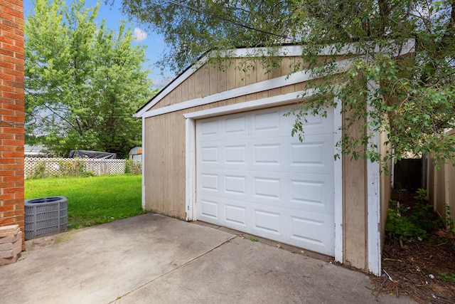 garage featuring central AC unit and a yard