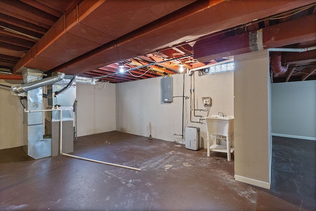 basement with sink, electric panel, and heating unit