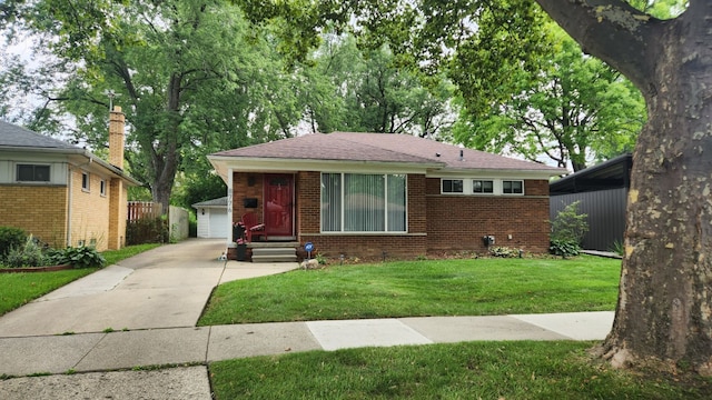 view of front of house with a front lawn, an outdoor structure, and a garage