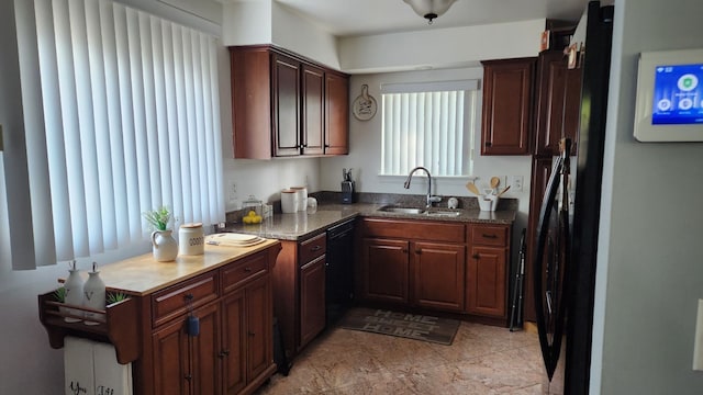 kitchen with dark stone countertops, sink, and black dishwasher