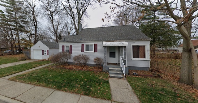 bungalow-style house featuring a front yard, a garage, and an outdoor structure