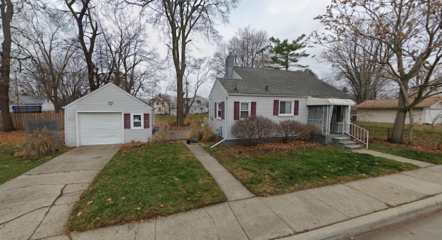 view of front facade featuring a front yard, a garage, and an outdoor structure