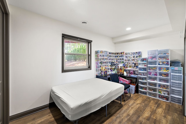 bedroom with dark hardwood / wood-style flooring