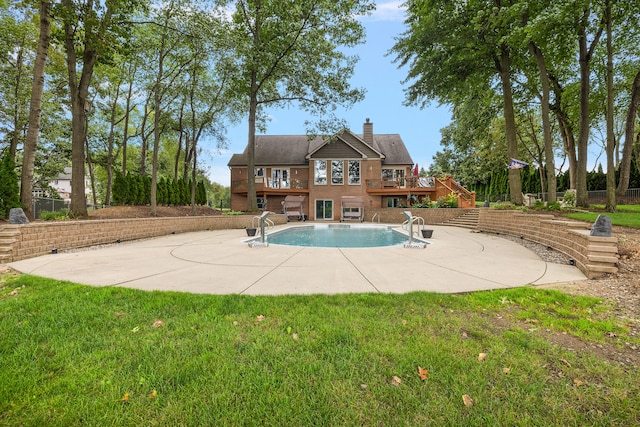 view of pool with a patio and a lawn