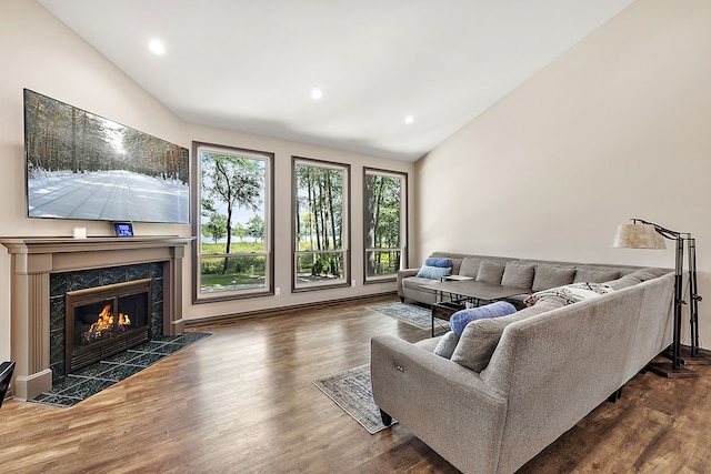 living room featuring a high end fireplace, dark wood-type flooring, and vaulted ceiling