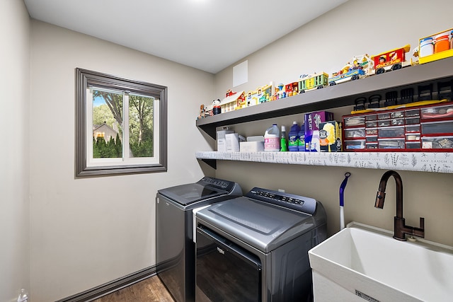 clothes washing area featuring washer and clothes dryer, dark hardwood / wood-style floors, and sink