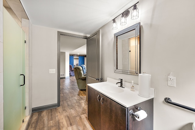 bathroom featuring hardwood / wood-style flooring, vanity, and walk in shower