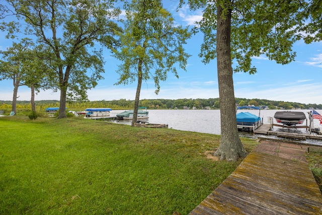 view of dock with a water view and a lawn