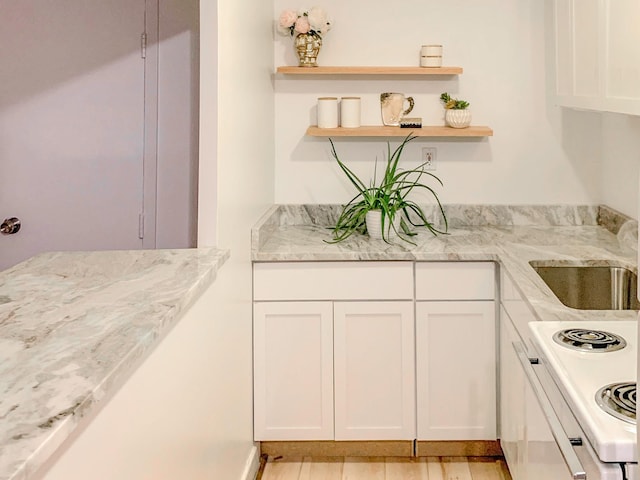 kitchen featuring white electric stove, white cabinets, light stone countertops, and open shelves