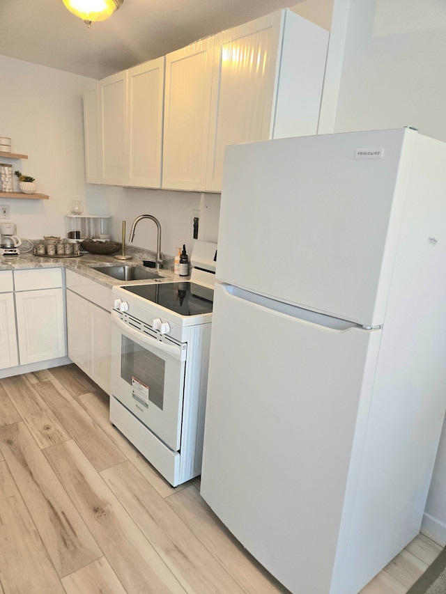 kitchen with open shelves, white appliances, a sink, light wood finished floors, and white cabinets