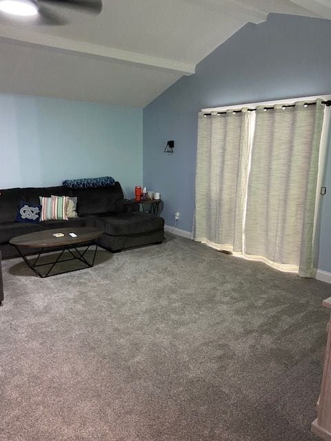 carpeted living room with vaulted ceiling with beams and ceiling fan