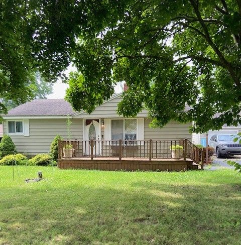 rear view of property featuring a lawn and a wooden deck