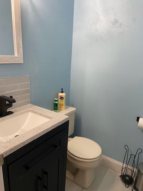 bathroom featuring tile patterned flooring, vanity, and toilet