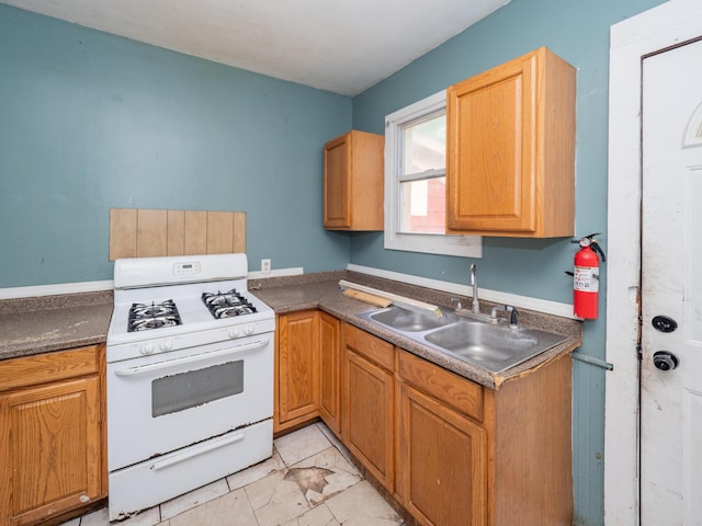 935 Osborne St, Kalamazoo, MI 49001 - kitchen with white gas range, a sink, and dark countertops