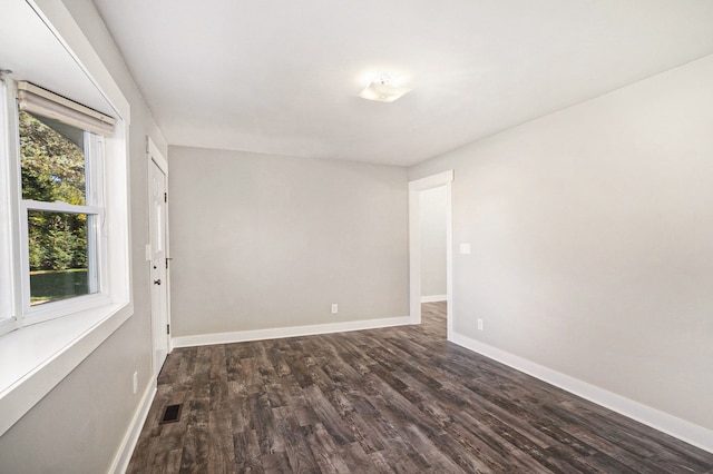 empty room with dark wood-type flooring