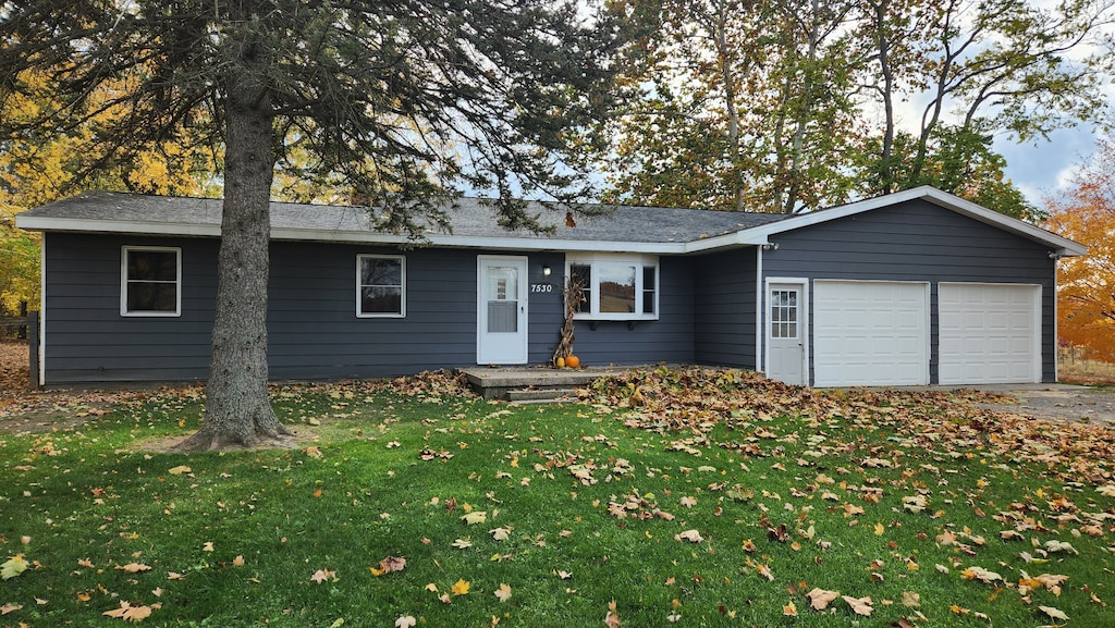 ranch-style house with a garage and a front yard