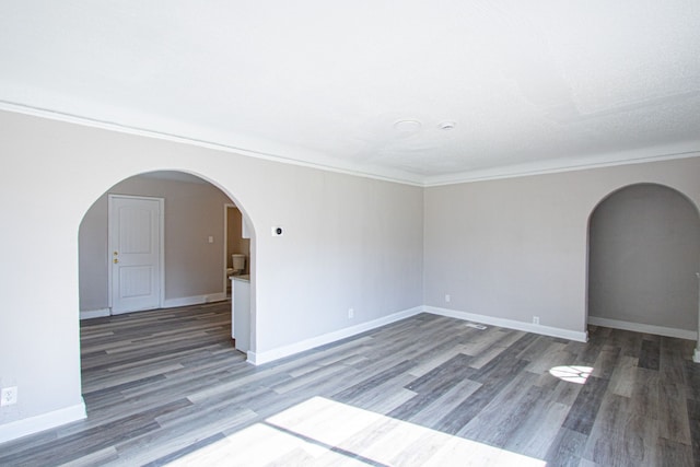 spare room featuring dark hardwood / wood-style floors and crown molding