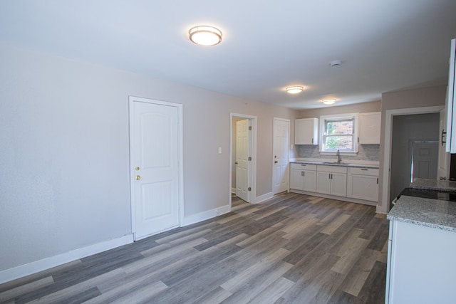 kitchen featuring tasteful backsplash, dark hardwood / wood-style flooring, white cabinets, and sink