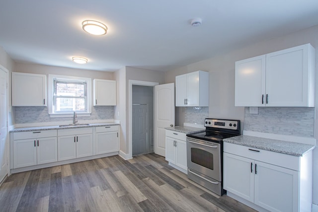 kitchen featuring white cabinets, sink, stainless steel range with electric cooktop, and hardwood / wood-style floors