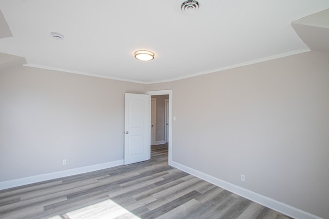 empty room with light hardwood / wood-style floors and ornamental molding