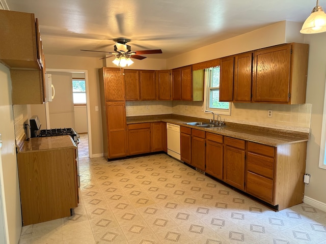 kitchen featuring white appliances, hanging light fixtures, a healthy amount of sunlight, and sink