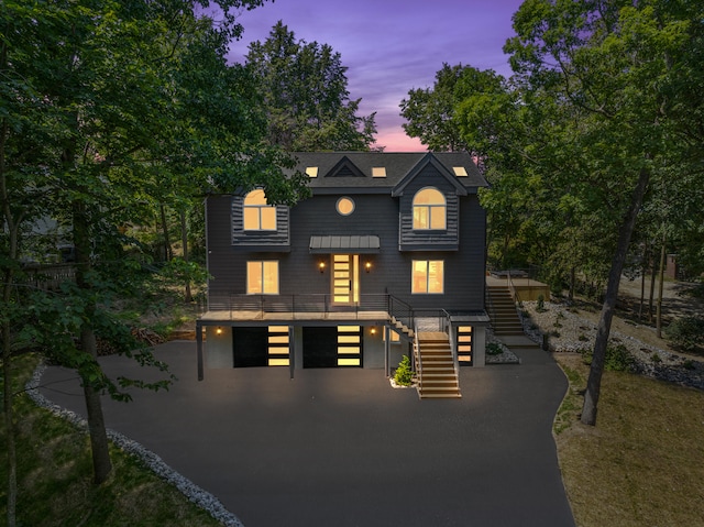 view of front of home with aphalt driveway, stairway, and an attached garage