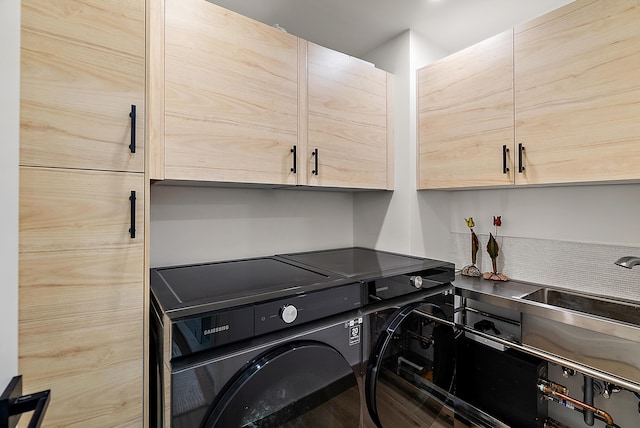 washroom with washing machine and dryer and cabinet space