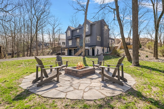 view of patio / terrace with a deck, a fire pit, and stairway