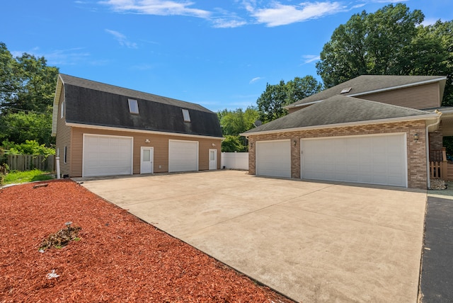 view of front of home featuring a garage and an outbuilding