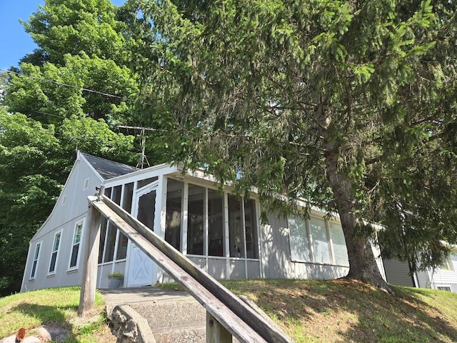 view of property exterior with a sunroom