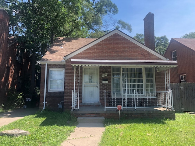 bungalow-style home featuring a front lawn and covered porch