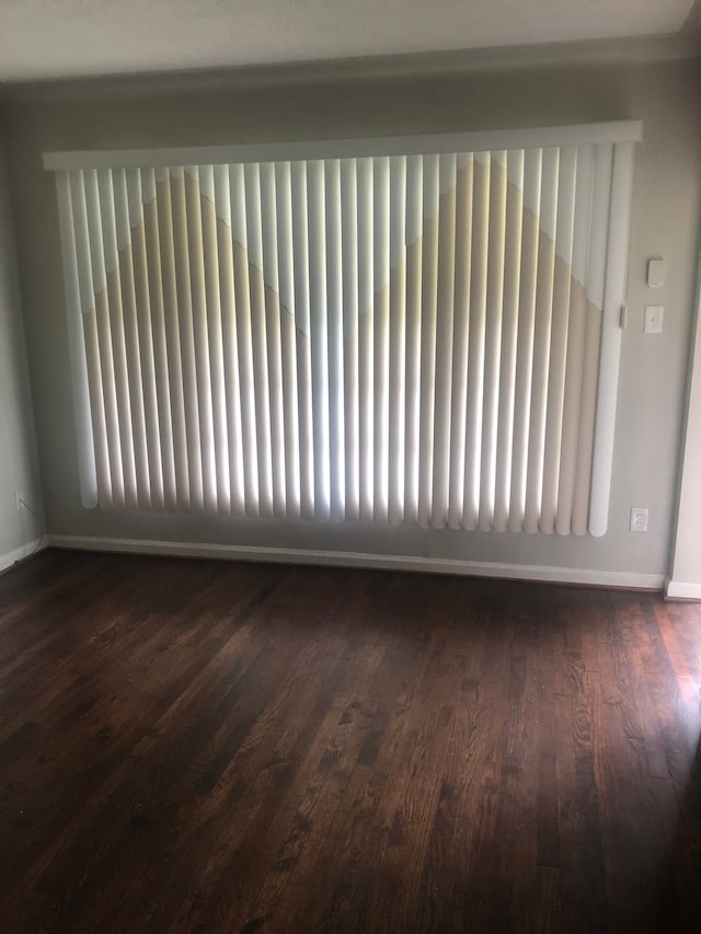 unfurnished room featuring dark hardwood / wood-style floors and radiator heating unit