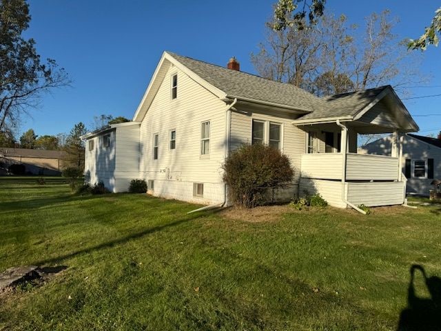 view of side of home with a yard