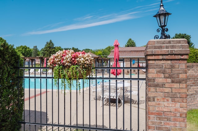 view of gate featuring a patio and a community pool