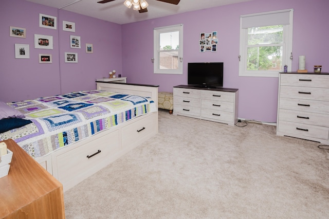 bedroom with ceiling fan and light carpet