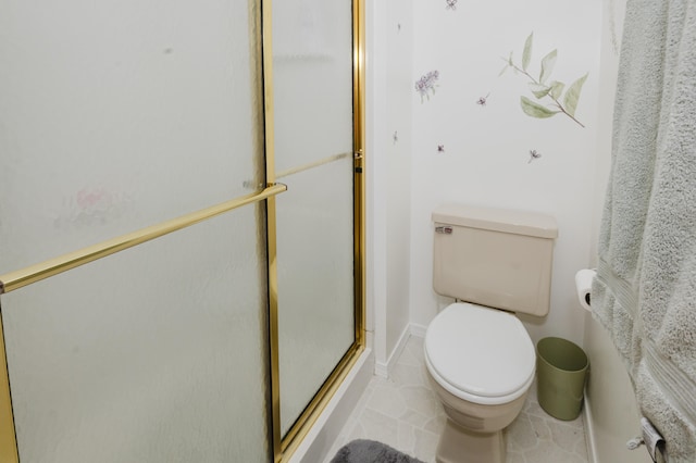 bathroom with a shower with shower door and toilet