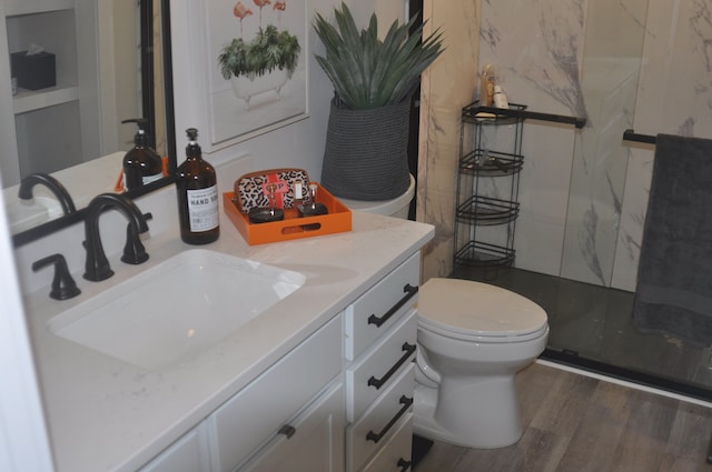 bathroom with vanity, toilet, wood-type flooring, and walk in shower