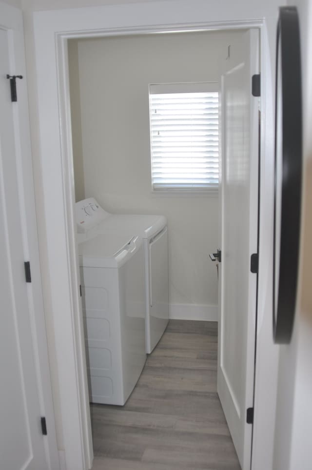 washroom with washer and clothes dryer and light hardwood / wood-style flooring