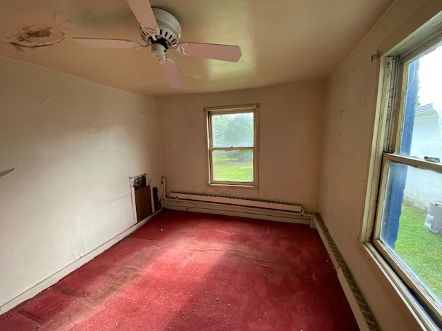 carpeted empty room featuring baseboard heating, a wealth of natural light, and ceiling fan